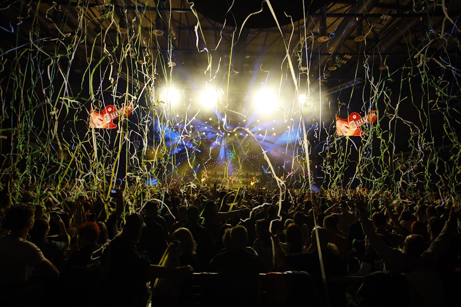 Captivating concert scene with excited crowd, bright lights, and colorful confetti filling the air.